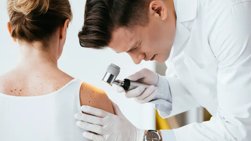 A doctor examining a woman's shoulder.