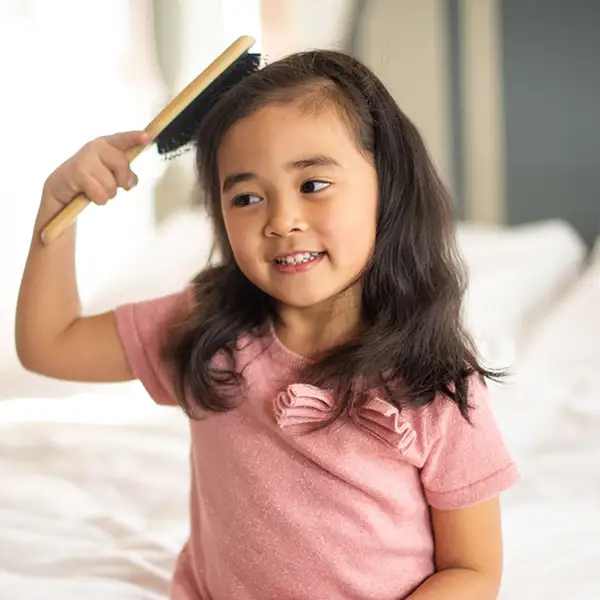 A little girl brushing her hair