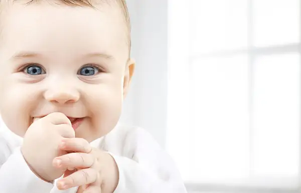 A photo of a baby smiling.